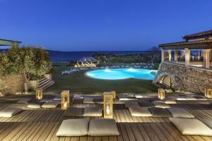 a backyard with a swimming pool and lounge chairs at Due Lune Puntaldia Resort & Golf in San Teodoro