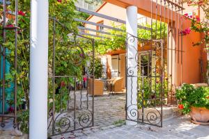 an entrance to a garden with an iron gate at Studio de charme Le Rose, 20m2, dans propriété au calme avec piscine by Le mas de Louise et Sacha in Solliès-Toucas