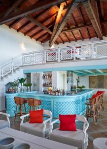 a bar in a restaurant with red pillows at Due Lune Puntaldia Resort & Golf in San Teodoro