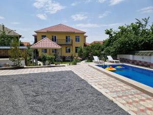 a backyard with a swimming pool and a house at Mountain Resort House in Gabala