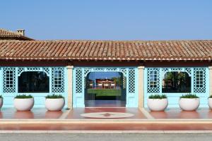 a gazebo with white pots in front of a building at Due Lune Puntaldia Resort & Golf in San Teodoro