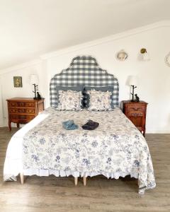 een slaapkamer met een bed met een blauwe en witte sprei bij LE VIEUX MOULIN in Bouhet