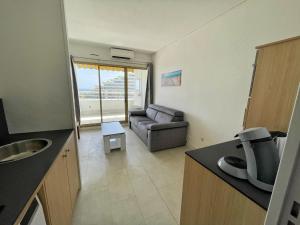 a kitchen and living room with a couch in a room at #902 MARINA RIVIERA BAY - Marina Baie des Anges in Villeneuve-Loubet
