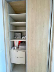a closet with white shelves and a wooden door at #902 MARINA RIVIERA BAY - Marina Baie des Anges in Villeneuve-Loubet