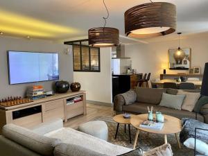 a living room with a couch and a flat screen tv at Appartement Mocca au coeur de Chamonix Mont-Blanc in Chamonix