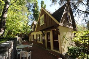 uma casa com um pátio, uma mesa e cadeiras em Saddleback Inn at Lake Arrowhead em Lake Arrowhead