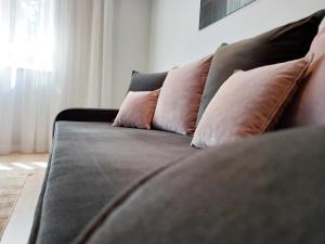 a couch with three pillows on it in a room at Klaipeda city center apartment in Klaipėda