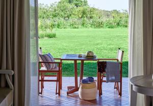 a table and chairs with a view of a field at Due Lune Puntaldia Resort & Golf in San Teodoro