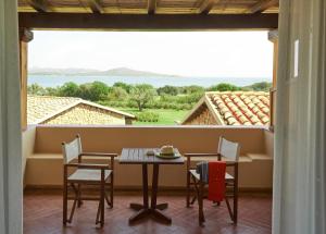 a table and chairs on a balcony with a view at Due Lune Puntaldia Resort & Golf in San Teodoro