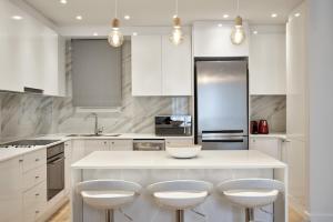 una cucina con isola bianca e 4 sgabelli di Spacious 2bd Apt in Prime Location next to Divani ad Atene