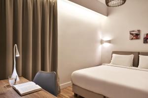 una camera d'albergo con letto e scrivania con un libro di Spacious 2bd Apt in Prime Location next to Divani ad Atene