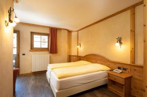 ein Schlafzimmer mit einem großen Bett und einem Tisch in der Unterkunft Hotel La Pastorella in Livigno