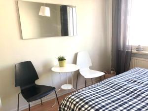 a bedroom with a bed and two chairs and a table at Scandinavian apartments Heart of the city Kamppi 1, 5, 6 in Helsinki