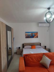 - une chambre avec un lit et un canapé orange dans l'établissement One Bedroom apartment, à San Ġiljan