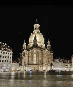 a large building with a clock tower at night at Premium City Appartmartement Dresden Nichtraucher in Dresden