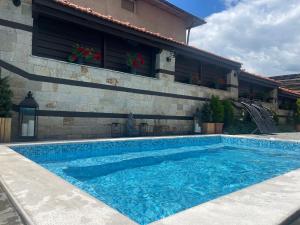 a swimming pool in front of a building at Seven Springs Hotel in Banya