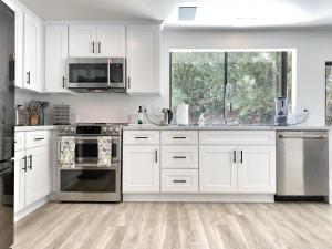 a kitchen with white cabinets and stainless steel appliances at OCLuxeBnB Private Resort Living Minutes from Beach in Laguna Hills