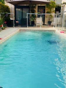 une grande piscine d'eau bleue devant une maison dans l'établissement Villa Elimia avec piscine chauffée, à Antibes