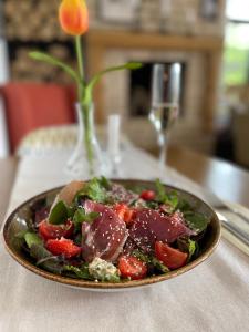 un plato de ensalada con carne y fresas en una mesa en Seven Springs Hotel en Bania