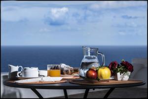 un tavolo con un piatto di frutta e una brocca di succo di Il Gelso Vacanze a Malfa