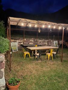 a picnic table and chairs under a tent with lights at CHALET LA BOLLINE in Valdeblore
