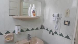 baño con lavabo y teléfono en la pared en Taharka Nubian House, en Asuán