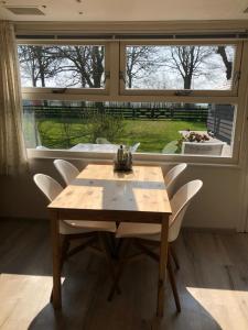 a table and chairs in a room with a window at Lekerweg 32 in Wijdenes