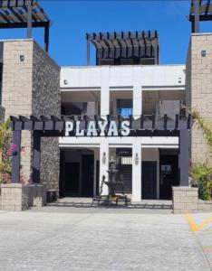 プエルト・ペニャスコにあるPlayas Hotel Suitesの遊びを読む看板のある建物