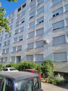 Un grand bâtiment avec des voitures garées devant lui dans l'établissement Apartment Vinka, à Split
