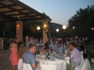 a group of people sitting at tables at a party at Eleonas hotel in Rovies