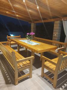 a wooden table and chairs on a patio at Apartments Branka in Zablaće