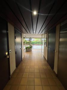 a hallway of an office building with doors and a tile floor at Petit studio Vincennes in Vincennes