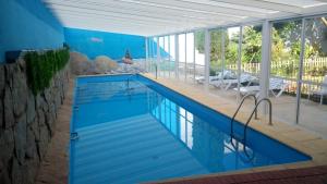 a swimming pool in a house with a blue wall at La Casona del Abuelo Parra in Villanueva de los Infantes