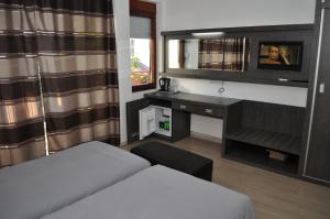 Schlafzimmer mit einem Bett, einem Schreibtisch und einem Spiegel in der Unterkunft Villa White Lake in Ohrid