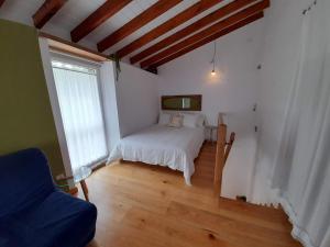 a bedroom with a white bed and a window at Gestiona2R - Casa en la playa, ideal parejas in Barro de Llanes