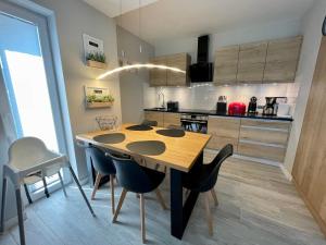 a kitchen with a wooden table and chairs at Apartament Pogorzelica - Baltic Park in Pogorzelica