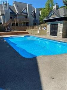 una gran piscina azul frente a una casa en The Perfect Staycation - Blue Mountain Studio en Blue Mountains