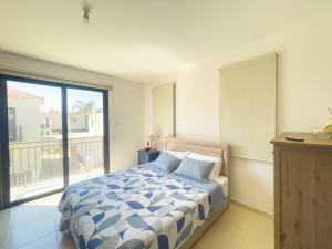 a bedroom with a bed and a balcony at Villa Chrysa in Protaras