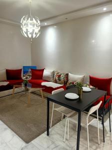 een woonkamer met een rode bank en een tafel bij Studio Des Nations Miramar Mohammedia in Mohammedia