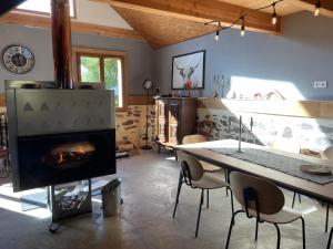 a living room with a fireplace and a table with chairs at CHALET LA BOLLINE in Valdeblore