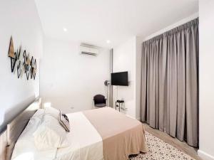 ein weißes Schlafzimmer mit einem Bett und einem Fenster in der Unterkunft Apartamento en el Corazón de Casco Viejo Panamá 13 in Panama-Stadt