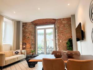 ein Wohnzimmer mit einem Tisch und einer Ziegelwand in der Unterkunft Apartamento en el Corazón de Casco Viejo Panamá 13 in Panama-Stadt