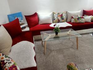 sala de estar con sofá rojo y mesa en Studio Des Nations Miramar Mohammedia, en Mohammedia