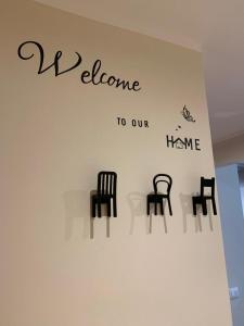 una pared con sillas en ella con las palabras bienvenidos a nuestra casa en MacchiabelliHome Centro Recco, en Recco