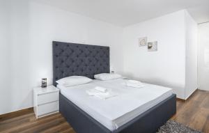 Un dormitorio con una cama grande con cabecero negro. en Villa Twins, en Crikvenica