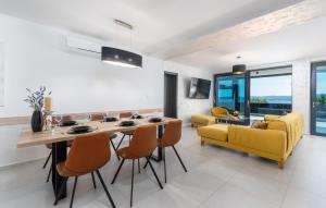 a kitchen and living room with a dining table and yellow chairs at Villa Twins in Crikvenica