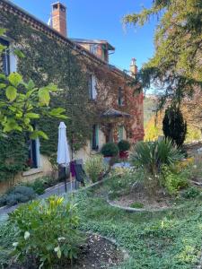 an old building with an umbrella in a garden at La Reynière in Serres