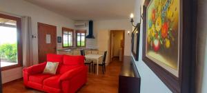 sala de estar con sofá rojo y cocina en The Black Horse Canarias - Adults Only en Maspalomas