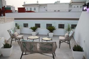 patio z krzesłami i stołami w budynku w obiekcie Luz, aire y mar Grupo AC Gestion w Kadyksie