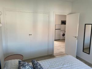 a white bedroom with a bed and a kitchen at Relax y sol in Torreguadiaro